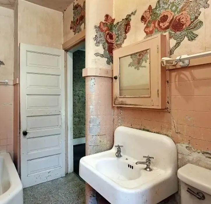 A bathroom with pink walls and a sink.