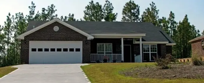 A brick home with a garage in front of it.